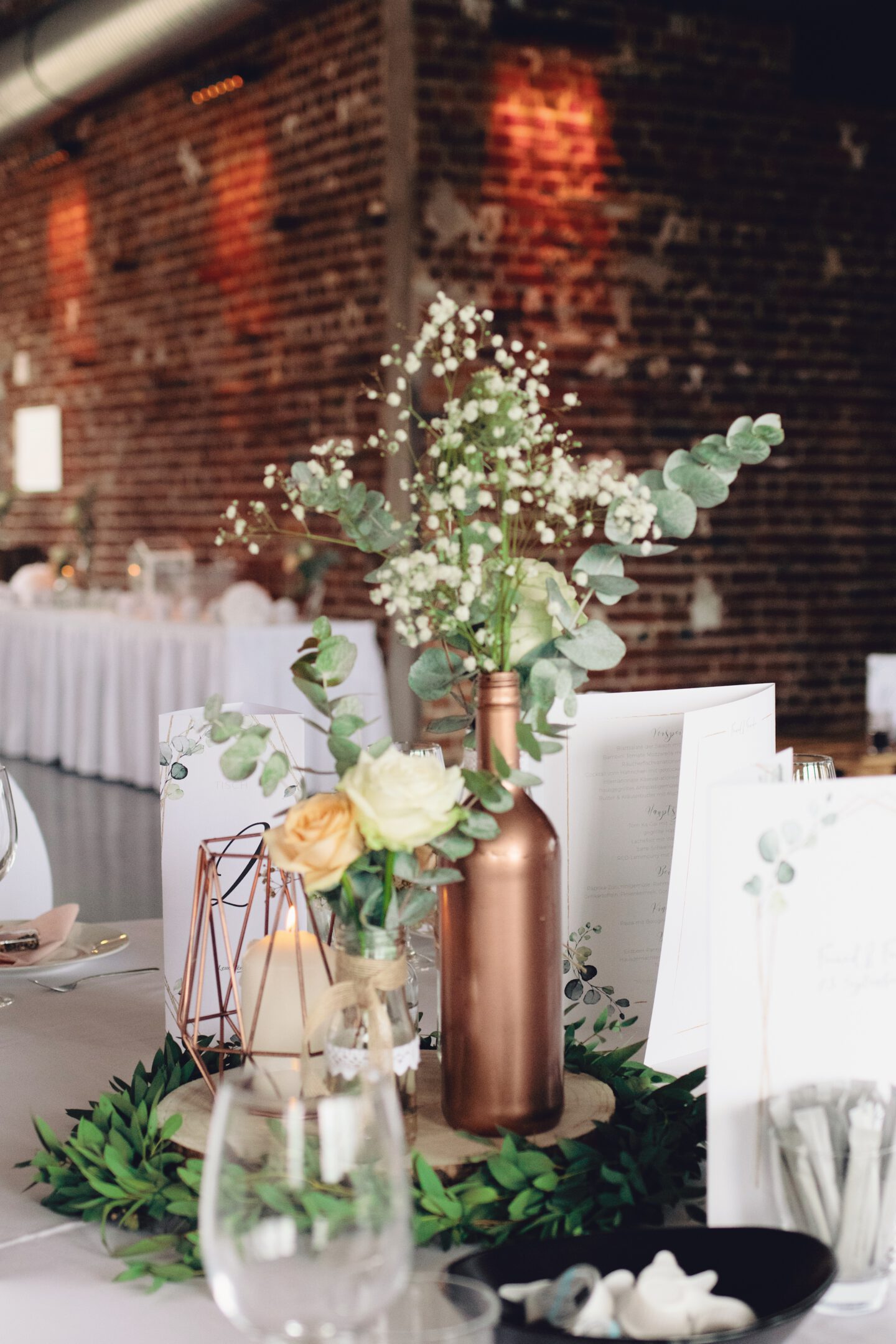 DIY Boho-Hochzeit: Deko mit Holzscheiben, kleinen Vasen, Kupferkerze und Eukalyptus