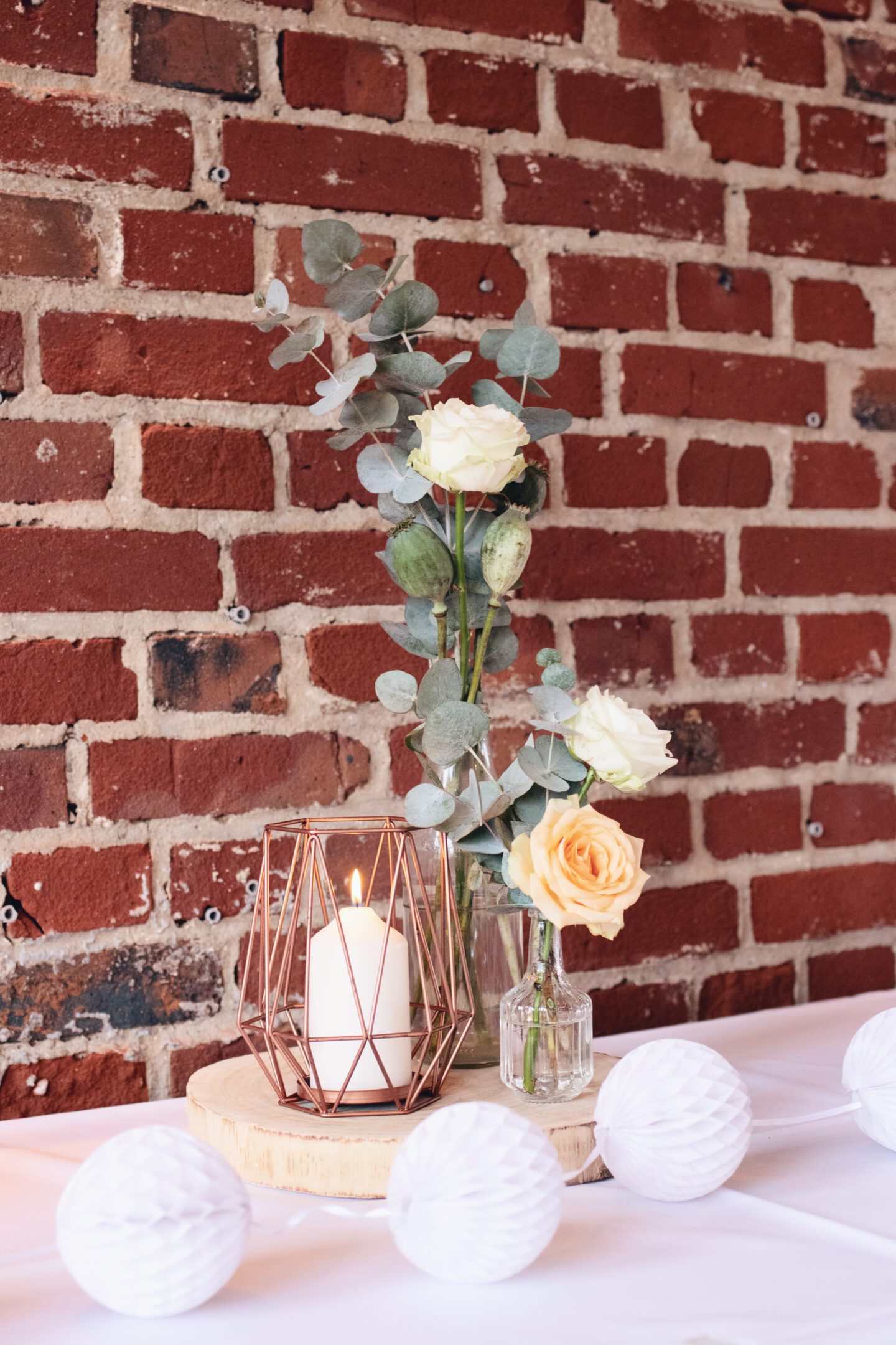 DIY Boho-Hochzeit: Deko mit Holzscheiben, kleinen Vasen, Kupferkerze und Eukalyptus