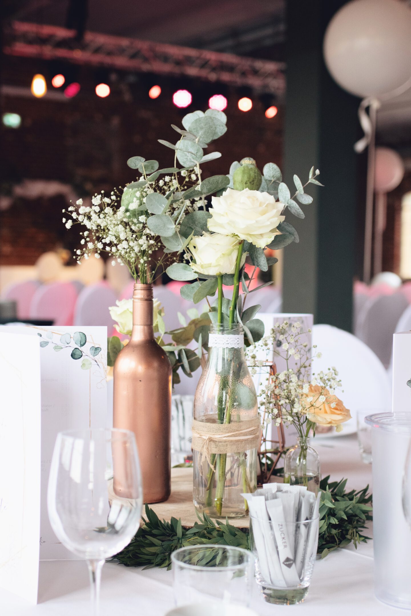 DIY Boho-Hochzeit: Deko mit Holzscheiben, kleinen Vasen, Kupferkerze und Eukalyptus