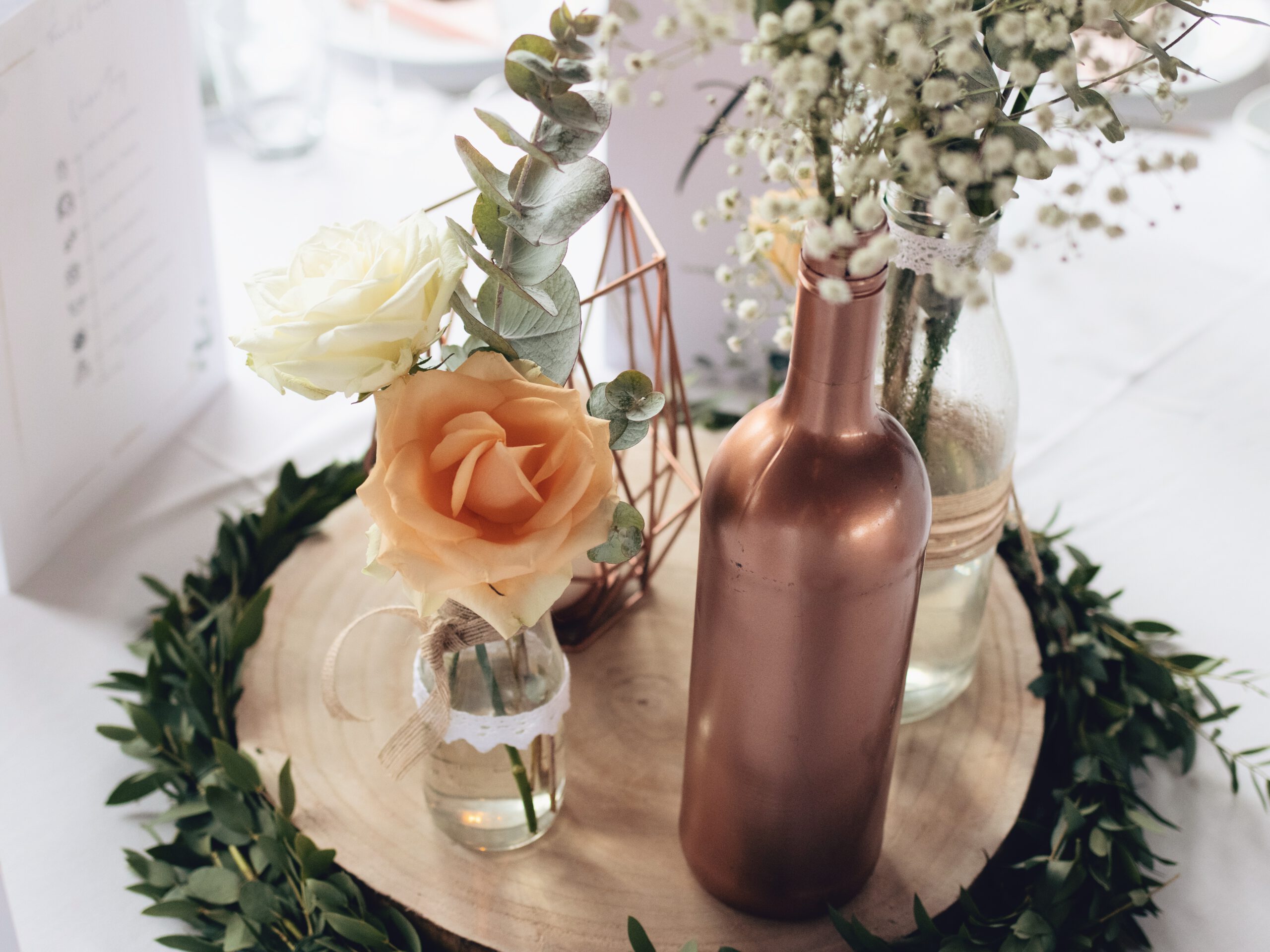 DIY Boho-Hochzeit: Deko mit Holzscheiben, kleinen Vasen, Kupferkerze und Eukalyptus