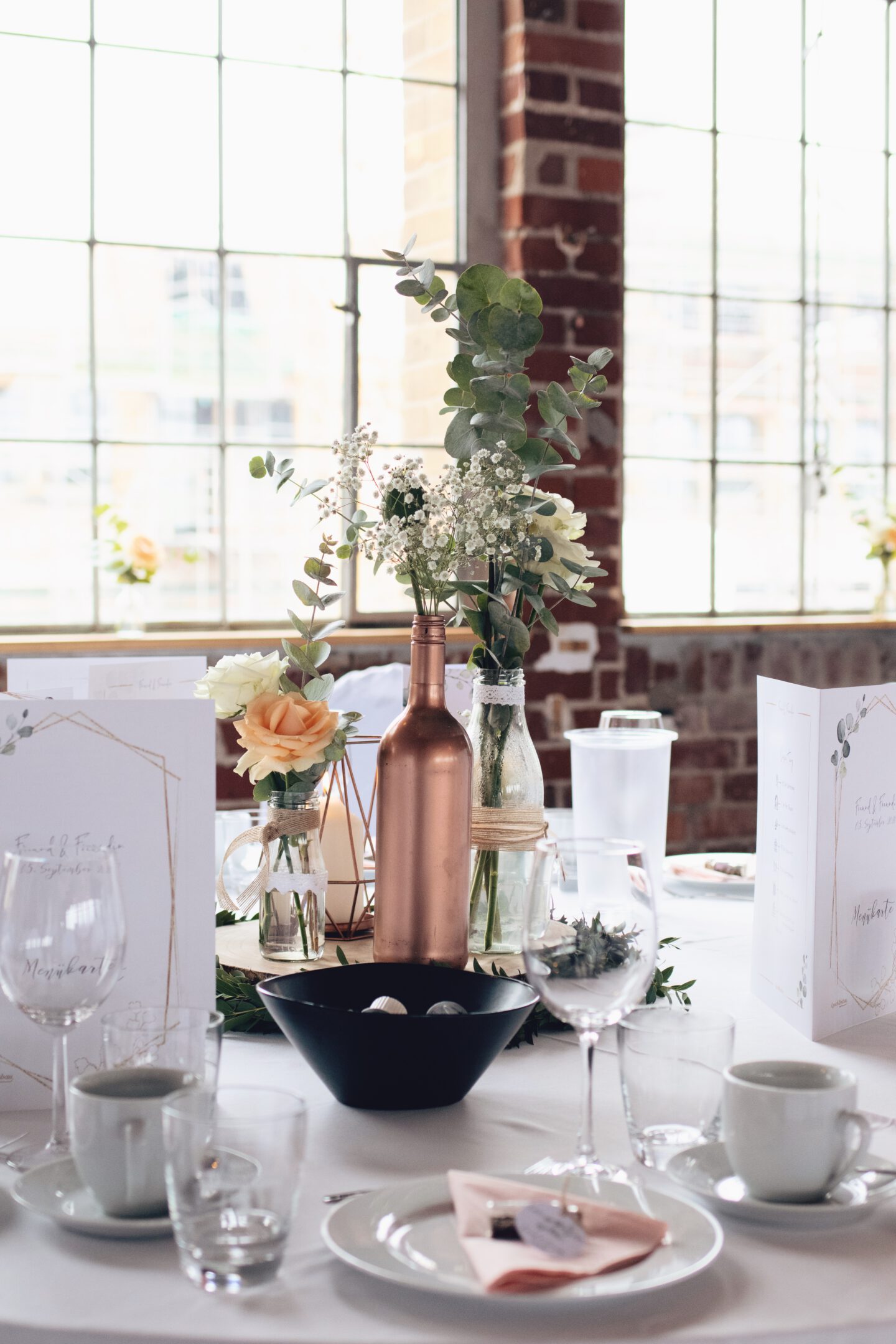 DIY Boho-Hochzeit: Deko mit Holzscheiben, kleinen Vasen, Kupferkerze und Eukalyptus